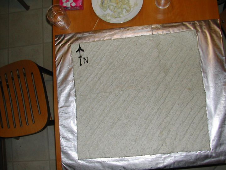 A sheet cake representing the sea, with compass arrow and waves to indicate the wind direction.